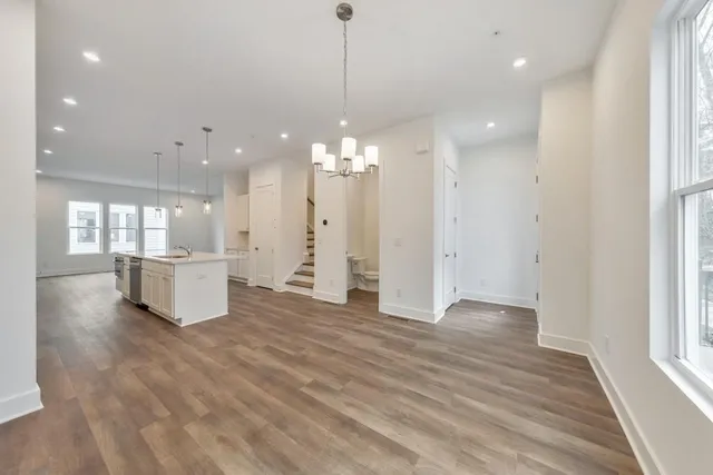 a view of a room with kitchen and wooden floor