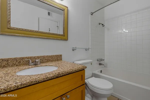 a bathroom with a granite countertop sink toilet and a bathtub