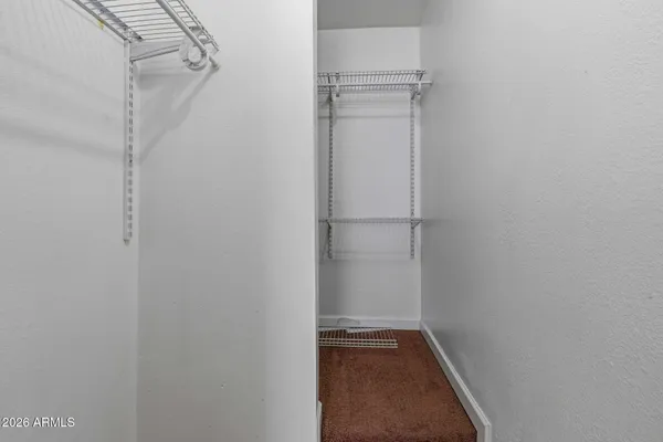 a view of walk in closet with empty racks