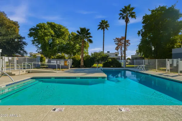 a view of swimming pool with outdoor seating and house in the background
