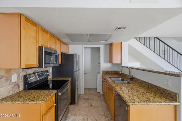 a kitchen with stainless steel appliances granite countertop a sink stove and refrigerator
