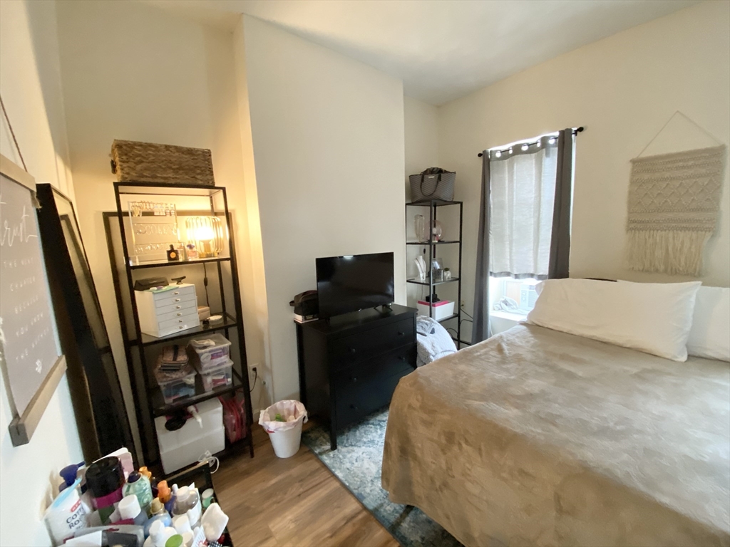 96 Hammond Street, Unit 3 Boston, MA 02120 - Photo 4 of 8 a bedroom with a bed and a flat tv screen