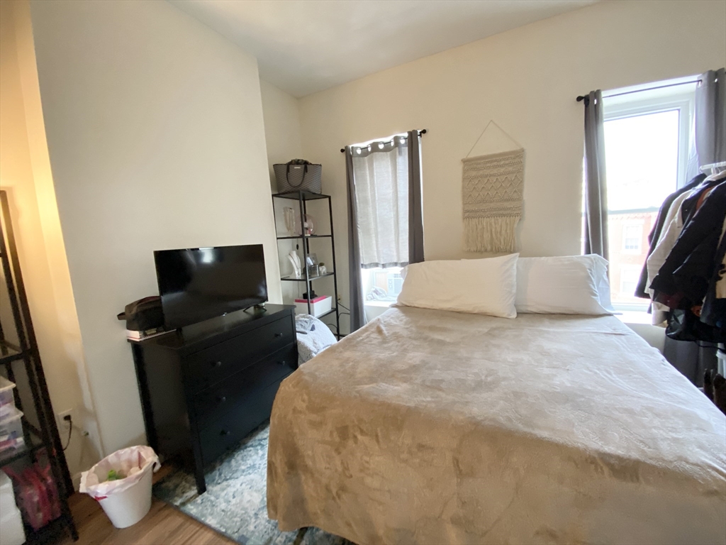 96 Hammond Street, Unit 3 Boston, MA 02120 - Photo 5 of 8 a bedroom with a bed and wooden floor