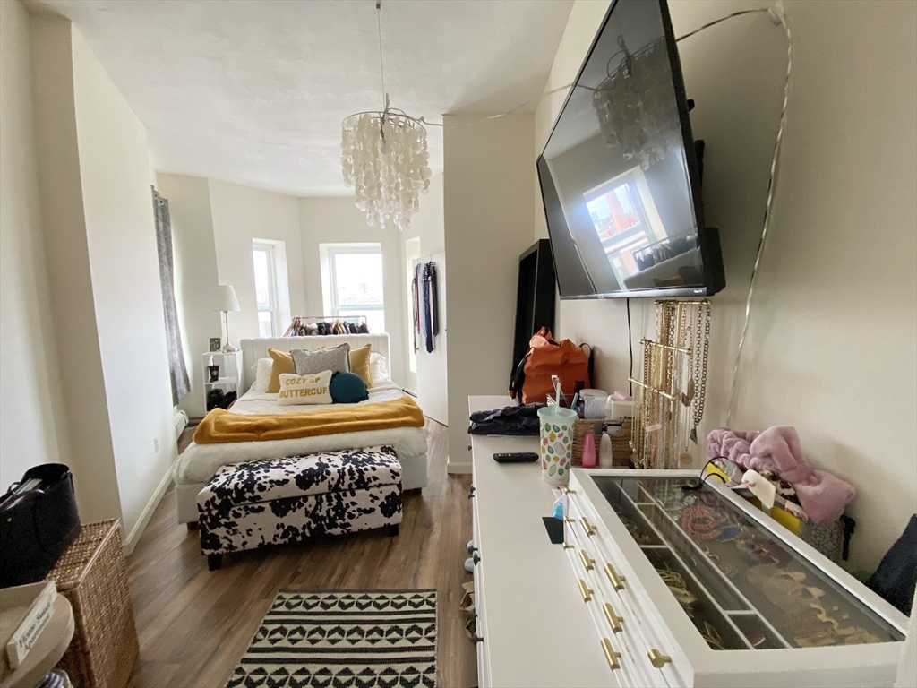 96 Hammond Street, Unit 3 Boston, MA 02120 - Photo 7 of 8 a bedroom with furniture and a chandelier