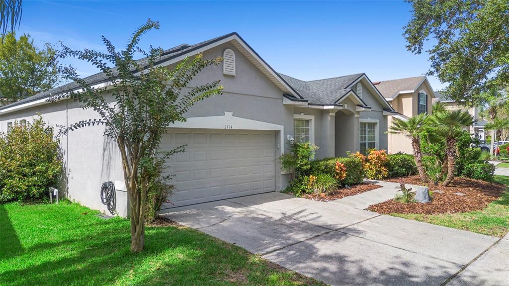 2414 Ridgemoor Drive Orlando, FL 32828 - Photo 2 of 45 a front view of a house with a yard and garage