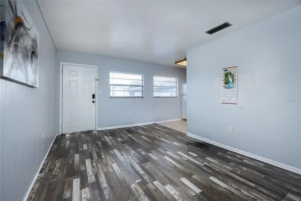 a view of empty room with window and wooden floor