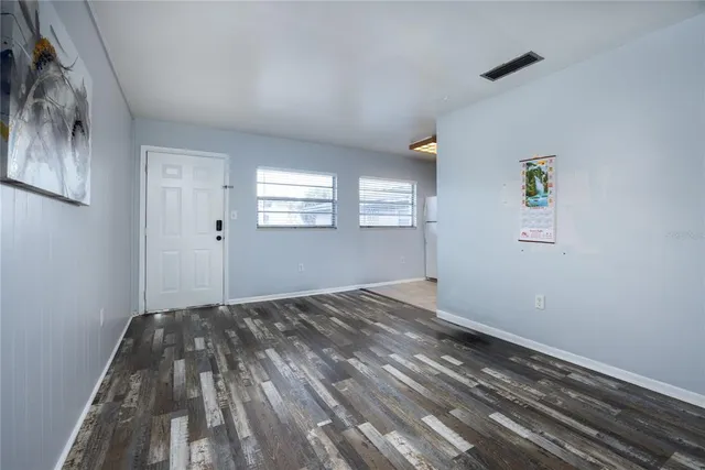 a view of empty room with window and wooden floor