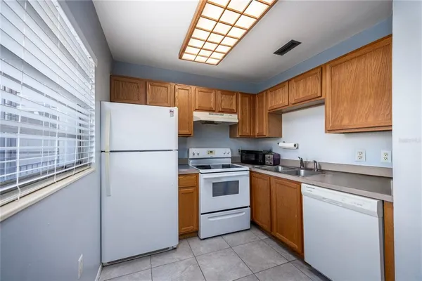 a kitchen with a sink a refrigerator and cabinets