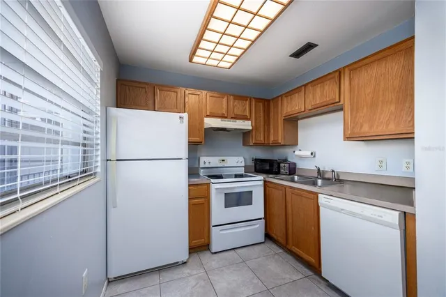 a kitchen with a sink a refrigerator and cabinets