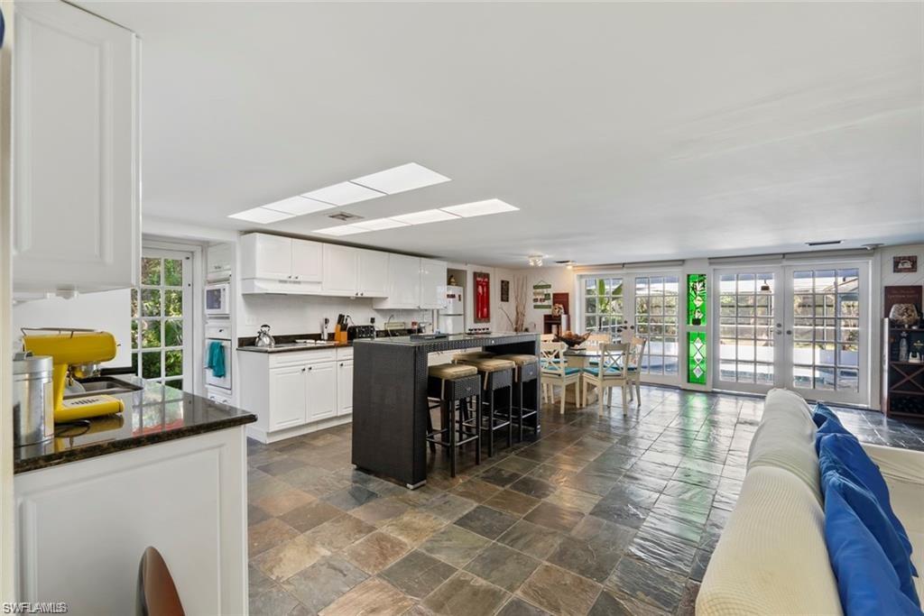3550 Hazel Road Naples, FL 34104 - Photo 43 of 43 a kitchen with a table chairs stove and cabinets