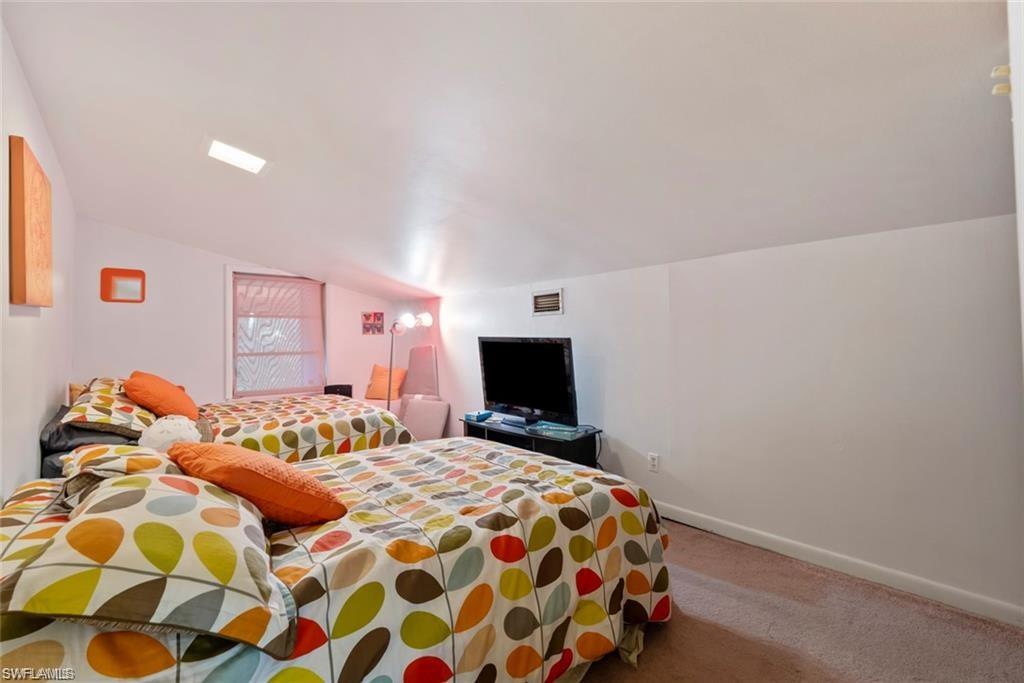 3550 Hazel Road Naples, FL 34104 - Photo 22 of 43 a bedroom with a bed and a flat screen tv