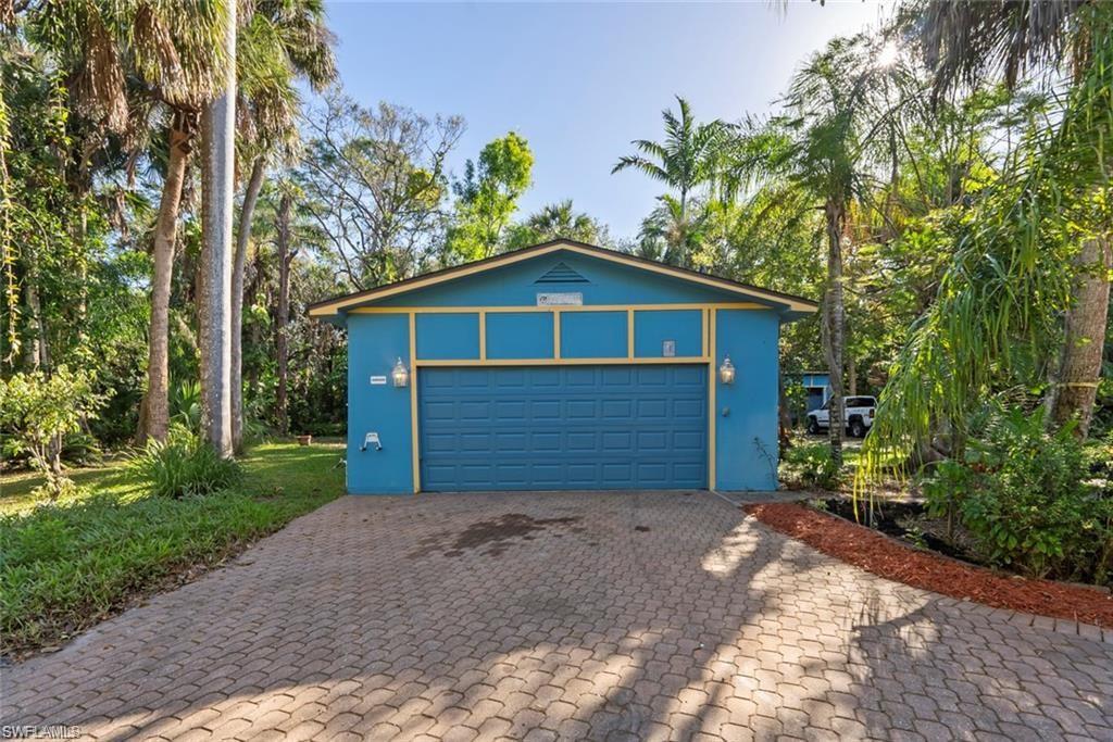 3550 Hazel Road Naples, FL 34104 - Photo 28 of 43 a front view of a house with a yard and garage