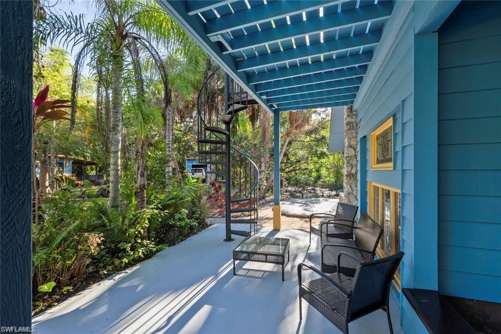 3550 Hazel Road Naples, FL 34104 - Photo 6 of 43 a porch with outdoor seating and trees in the background