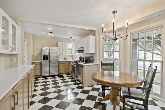 a kitchen with stainless steel appliances a dining table chairs and granite counter tops