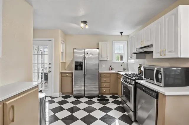 a kitchen with stainless steel appliances granite countertop a refrigerator stove and sink