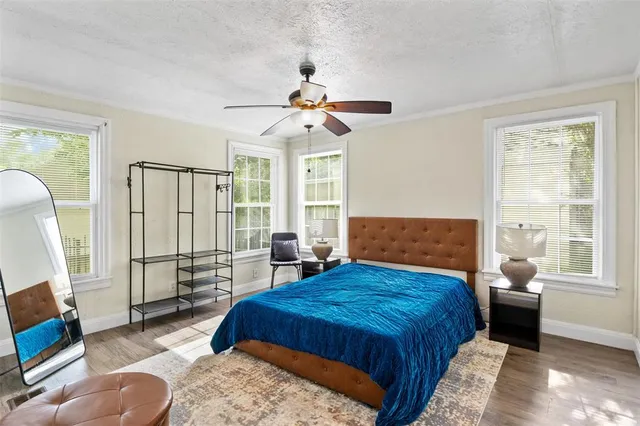 a spacious bedroom with a bed a couch and a window