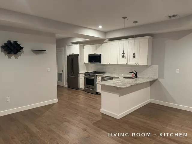 a view of kitchen with stainless steel appliances granite countertop a stove top oven a sink and a refrigerator