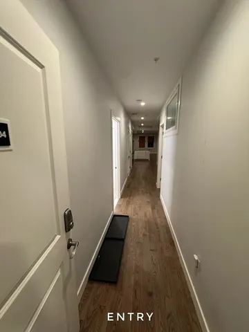 a hallway with wooden floor and staircase