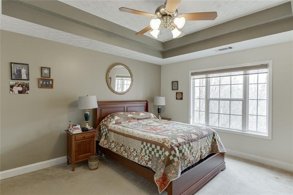 124 Edgewater Court Braselton, GA 30517 - Photo 34 of 54 a bedroom with a bed and a chandelier