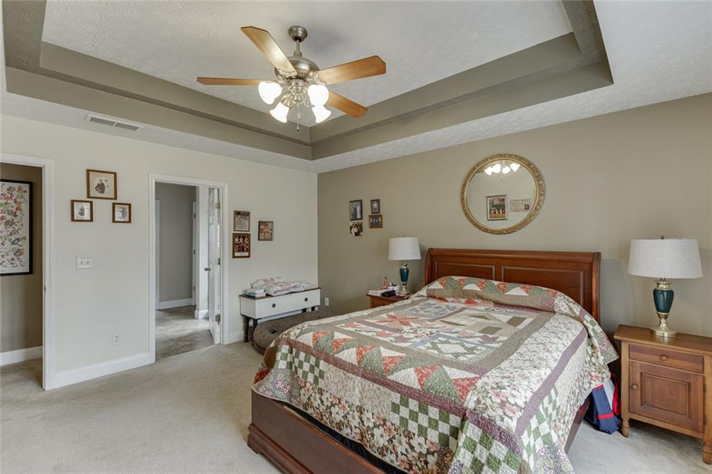 124 Edgewater Court Braselton, GA 30517 - Photo 35 of 54 a bedroom with a bed and a chandelier