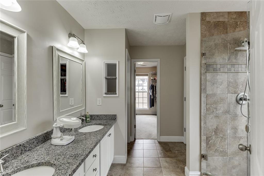 124 Edgewater Court Braselton, GA 30517 - Photo 37 of 54 a bathroom with a granite countertop sink a mirror and shower