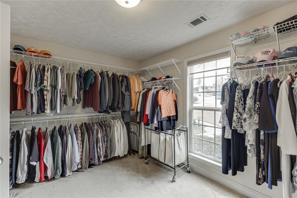 124 Edgewater Court Braselton, GA 30517 - Photo 40 of 54 a view of walk in closet with clothes and shoes