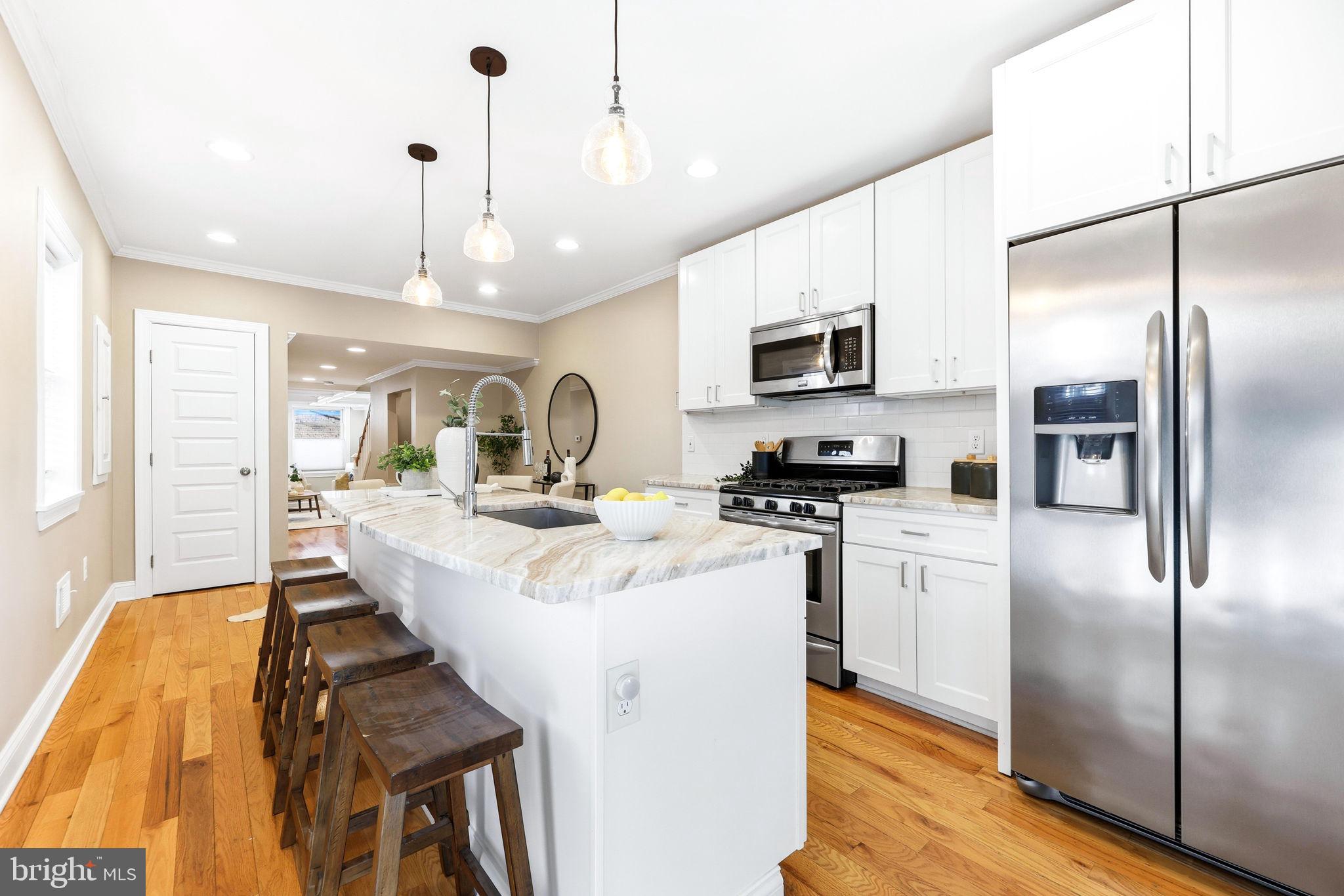 404 South Castle Street Baltimore, MD 21231 - Photo 12 of 47 a kitchen with stainless steel appliances granite countertop a sink refrigerator and microwave