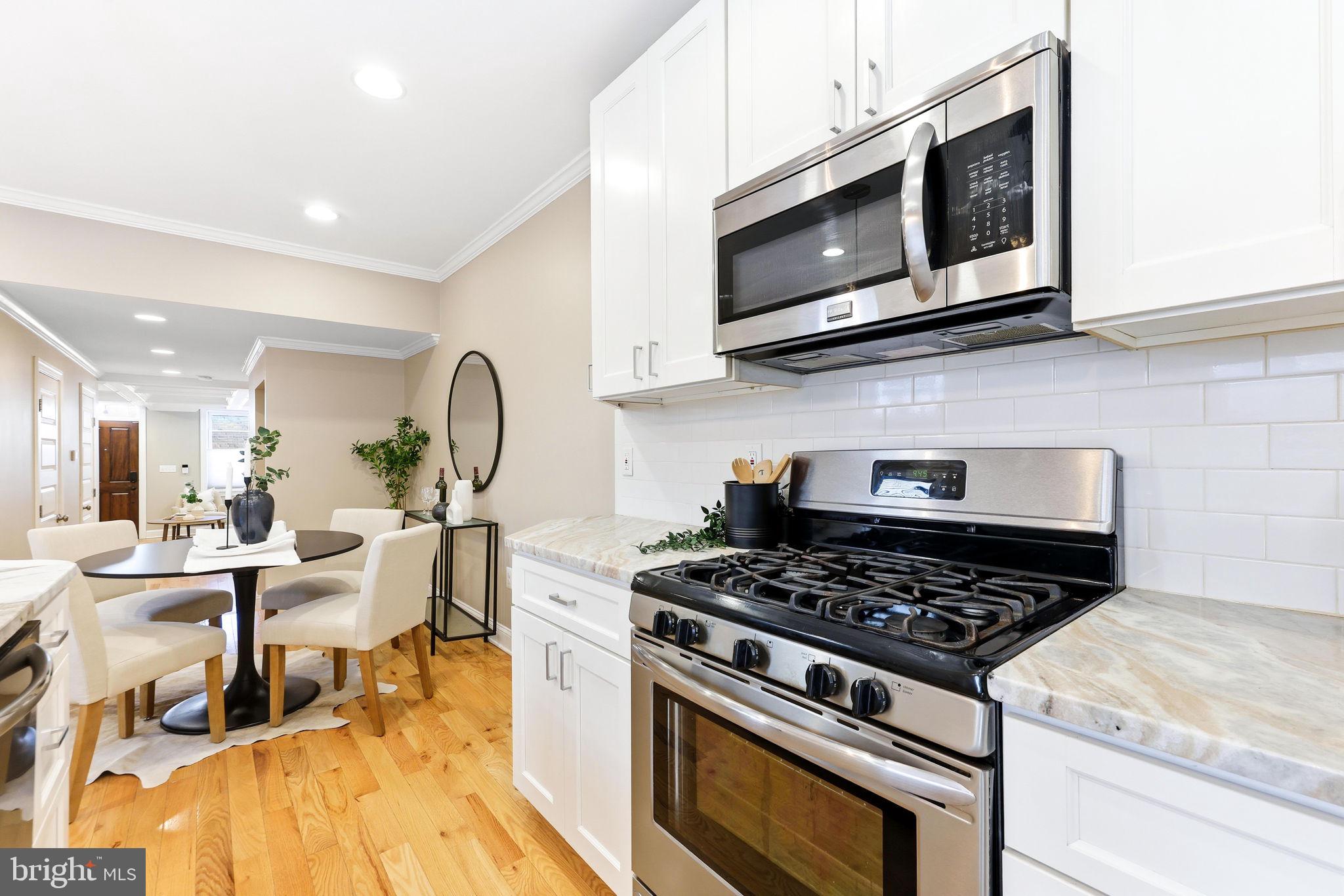 404 South Castle Street Baltimore, MD 21231 - Photo 14 of 47 a kitchen with stainless steel appliances granite countertop a stove and a microwave