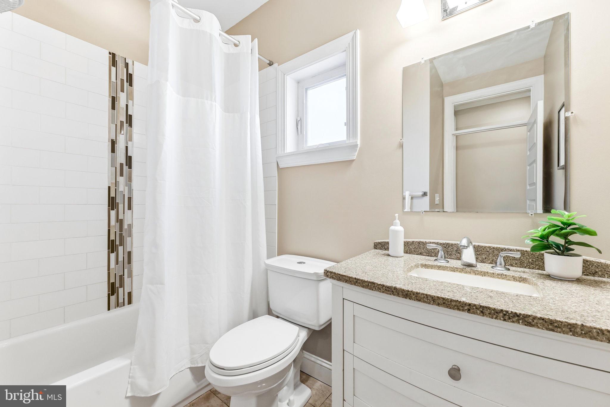 404 South Castle Street Baltimore, MD 21231 - Photo 31 of 47 a bathroom with a granite countertop toilet a sink and a bathtub
