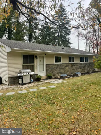 a front view of house with yard and trees in the background