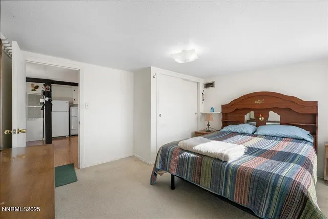 a bedroom with a bed a couch and a potted plant on the dresser