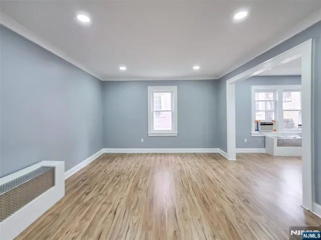 a view of empty room with wooden floor and a bathroom