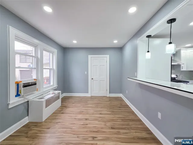 a view of a kitchen with a sink and dishwasher with wooden floor
