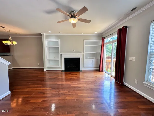 a view of an empty room with a fireplace and a window