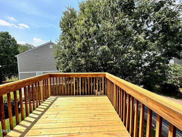 a view of balcony with wooden floor and fence