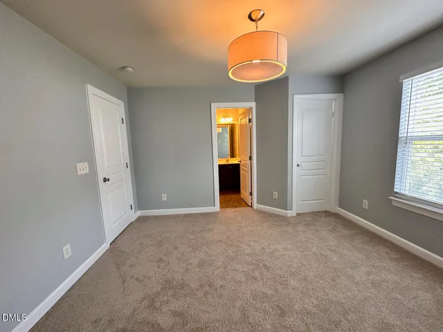 an empty room with a window and chandelier