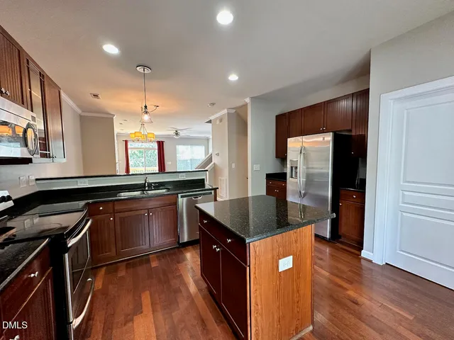 a kitchen with stainless steel appliances granite countertop a sink a stove and a refrigerator