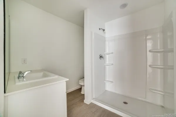 a bathroom with a granite countertop sink mirror and shower