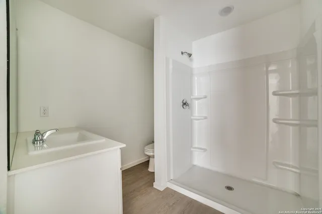 a bathroom with a granite countertop sink mirror and shower