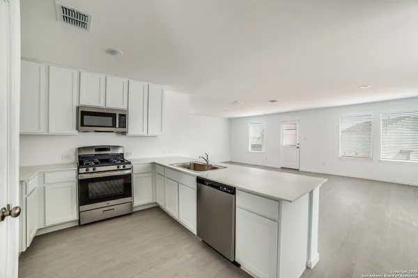 a kitchen with stainless steel appliances granite countertop a sink and a stove