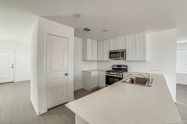a kitchen with a sink a stove and cabinets
