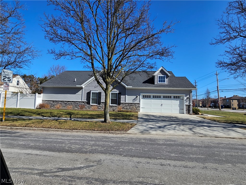 7462 Pearl Road Cleveland, OH 44130 - Photo 2 of 32 Side view of home with drive way, garage door, landscaping and 6 ft white vinyl privacy fence