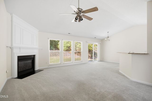 a view of an empty room with a fireplace and a window
