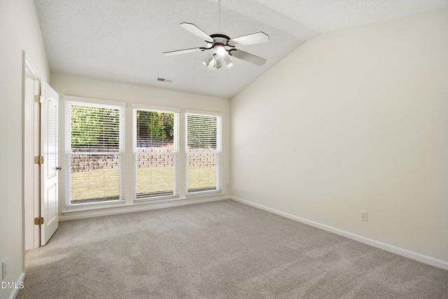 an empty room with a ceiling fan and window