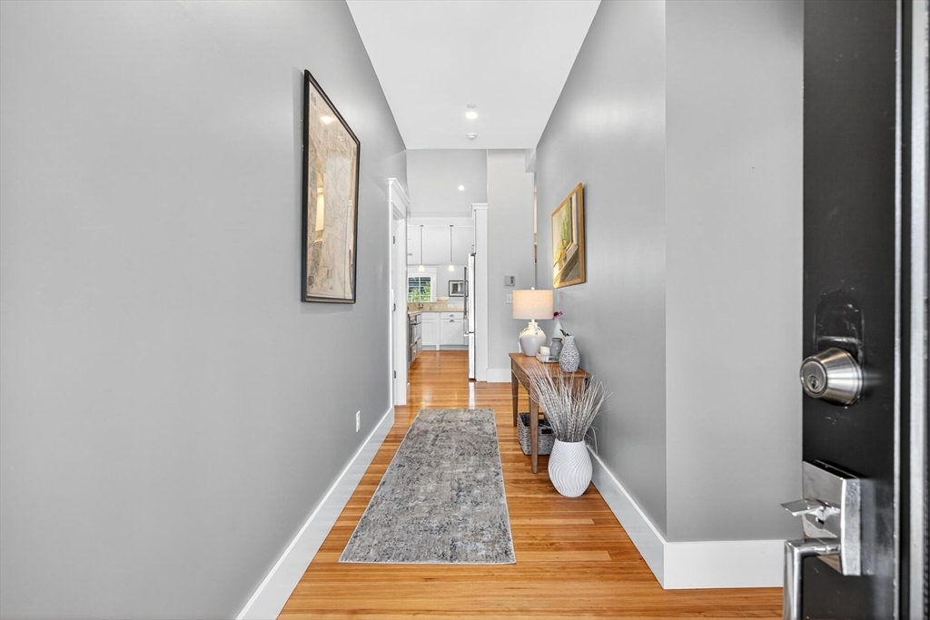 950 Massasoit Road, Unit 3 Eastham, MA 02642 - Photo 6 of 42 a hallway with front door wooden floor and chair