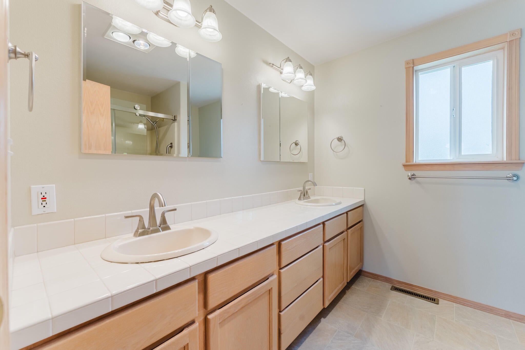 3626 Southwest Volcano Court Redmond, OR 97756 - Photo 40 of 89 Dual vanities and mirrors in the primary suite. The window allows natural light into the space.
