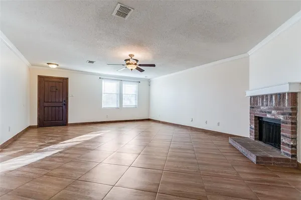 an empty room with windows and fireplace