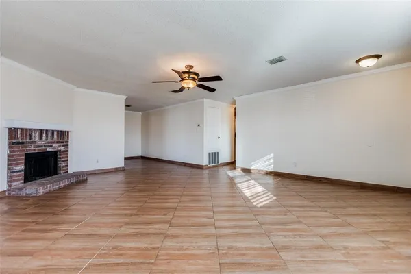 a view of an empty room with a fireplace and a window