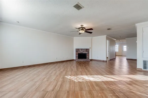 a view of empty room with wooden floor and ceiling fan