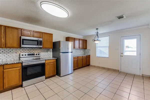 a kitchen with stainless steel appliances granite countertop a stove top oven a sink and dishwasher